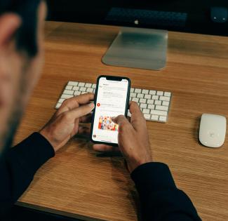 man holding phone while leaning on table by charlesdeluvio courtesy of Unsplash.