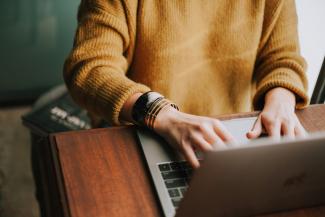 person using laptop computer by Christin Hume courtesy of Unsplash.