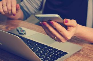 woman holding silver iPhone 6 by Firmbee.com courtesy of Unsplash.